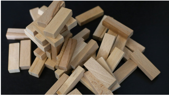 Wooden blocks falling like dominos representing title company red flags and potential deal collapse